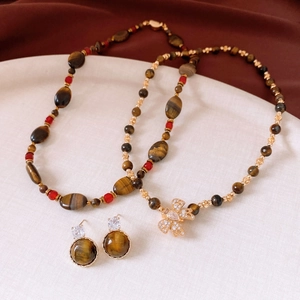 Vue détaillée du coffret bijoux en œil de tigre plaqué or 18k avec pendentif papillon