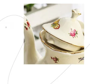 Detail of vintage ceramic teapot featuring floral patterns and gold-painted rims