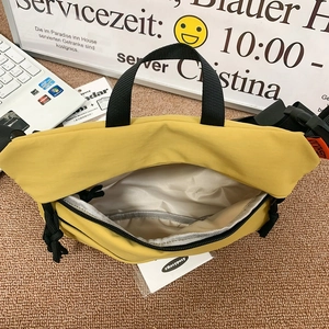 Minimalist yellow nylon crossbody sling bag with spacious interior and black strap