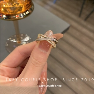 Detail of cross-layered gold ring with pave crystals and rectangular cubic zirconia