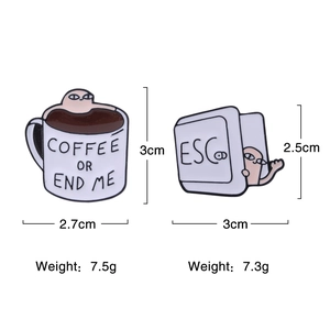 Detail showing cartoon coffee cup and ESC key enamel pins with specific measurements