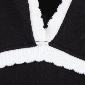 Détail rapproché de la bordure côtelée blanche sur le tissu de la robe noire