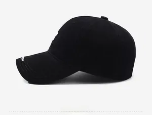 Side view of black washed cotton baseball cap featuring white embroidery on the curved brim