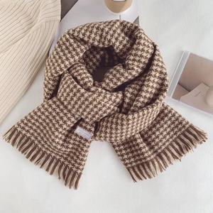 Detail shot of wool blended houndstooth scarf with soft fringe and stylish brown checks