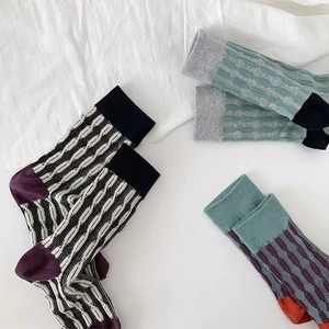 Three pairs of vintage cotton blend crew socks with retro striped patterns and contrast colors
