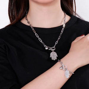 Detail of Hamsa hand pendant necklace and bracelet set with toggle clasp on model