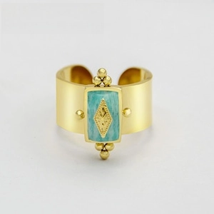Detailed macro of vintage wide open ring with blue stone and gold engraved diamond patterns
