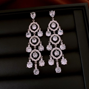 Detailed close-up of luxury tiered tassel earrings with cubic zirconia in a jewelry box
