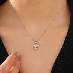 Detail of silver necklace with three pearl clusters and white zircon on a model