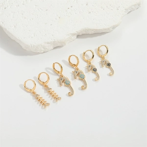 Exotic golden seahorse and fishbone earrings set with blue accents and white zircons