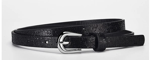 Detailed macro view of black sequin skinny belt featuring a silver horseshoe pin buckle