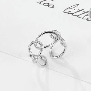Detailed macro view of interlocking silver rings featuring twisted and smooth metal textures