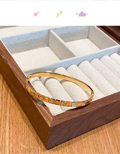 Detail view of gold titanium steel square block bracelet with embedded white zircons