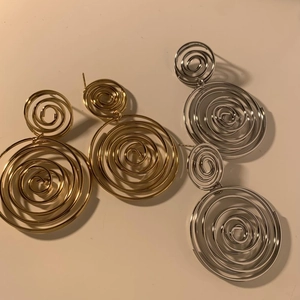 Spiral metal hoop earrings in gold and silver finish with minimalist design