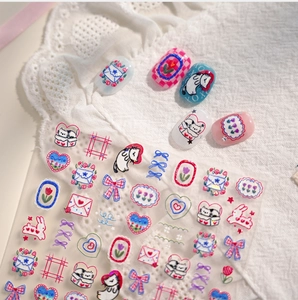 Close-up of embossed cartoon nail stickers featuring cute cats, hearts and tulip patterns