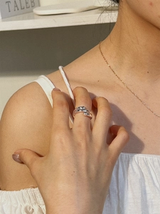 Detail view of s925 sterling silver minimalist double-wrap ring on model's finger