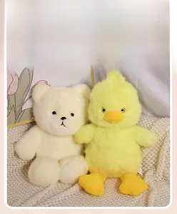 Detailed plush texture of cute cream teddy bear and yellow duck toys on a soft blanket