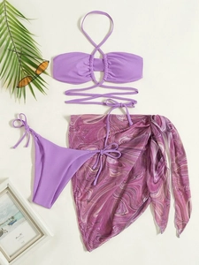 Detail view of purple three-piece bikini set with marble print sarong and neck tie top