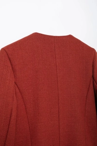 Gros plan sur la texture tissée d'une veste en tweed de couleur rouge terre cuite