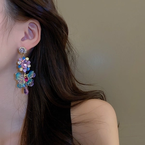 Detail shot of vintage butterfly earrings with multicolored crystals and gold metal finish