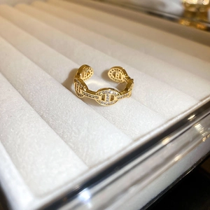 Detail of gold-plated Chaine d'Ancre ring with cubic zirconia on white velvet box