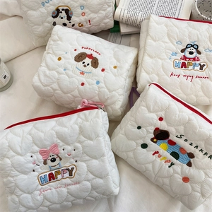 Detail of white quilted heart pattern makeup bag with cute dog embroidery and zipper