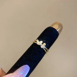Detailed close-up of a layered gold butterfly ring with textured matte wings on display