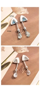 Macro detail of cat ear cartilage studs showing screw back and 2.2cm drop length