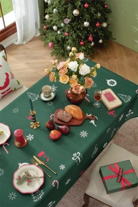 Festive dark green Christmas tablecloth with snowflake and reindeer print on dining table
