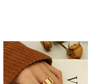Detail of 18K gold plated geometric chain ring worn on finger with aesthetic background