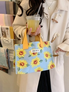 Light blue canvas tote bag with sunflower print and yellow handles for lunch or daily commute