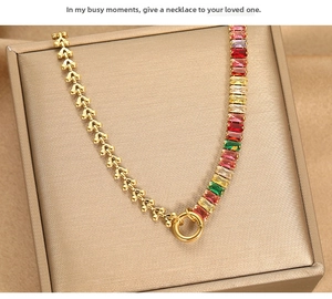 Detail of gold necklace featuring rainbow baguette stones and a round spring clasp