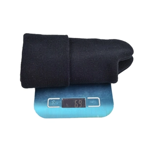 Detail shot of a black knitted beanie on a scale showing a product weight of 69 grams