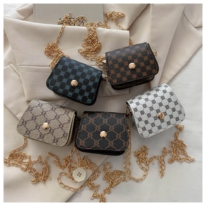 Flat lay of multiple PU leather crossbody bags with chain straps and monogram patterns