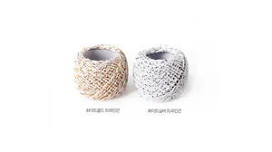 Detail of white-gold and white-silver 3-strand twisted cotton baker twine rolls