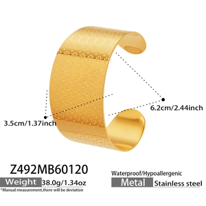 Détail du bracelet manchette large en acier inoxydable doré 18k avec motif floral