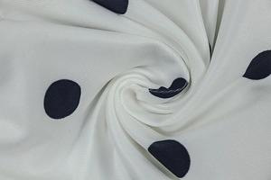 Detailed view of high-quality black polka dot print on white twill fabric for A-line dress