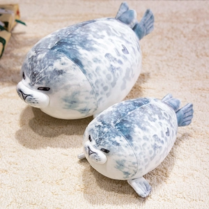 Pair of soft grey spotted seal plush toys in different sizes on a cozy beige rug