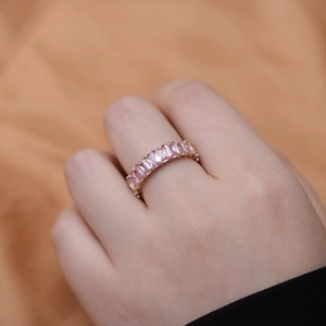 Macro detail of a 925 silver ring featuring a large pink rectangular zircon on a golden band