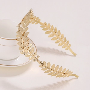 Golden vintage leaf headband made of metallic material on white background with tea set