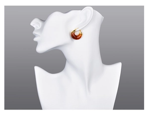 Detail view of vintage amber resin and gold metal C-shaped earrings on a model bust