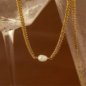 Bohemian chunky chain necklace with baroque pearl drop on a textured background