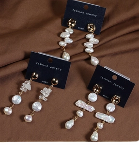 Detailed view of baroque pearl drop earrings with 925 silver needles and gold finish