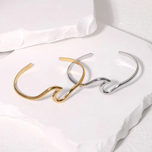 Bracciali aperti ondulati minimalisti in acciaio al titanio oro e argento su pietra bianca