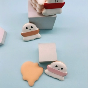 Cute cartoon marshmallow makeup puffs in ghost and cloud shapes on blue backdrop