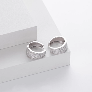 Close-up of 925 sterling silver hoop earrings with pave-set cubic zirconia on a white stand