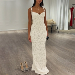 Detail view of white lace maxi dress featuring delicate floral patterns and slim fit