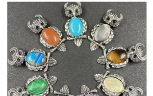 Close-up of owl pendants in multiple colors with natural crystal stones and silver texture