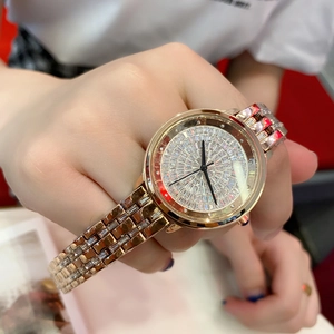 Close-up of rose gold women's watch with crystals on dial and band worn by a model