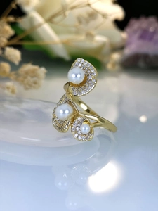 Macro shot of gold lotus petal ring with white pearls and sparkling pavé zircons